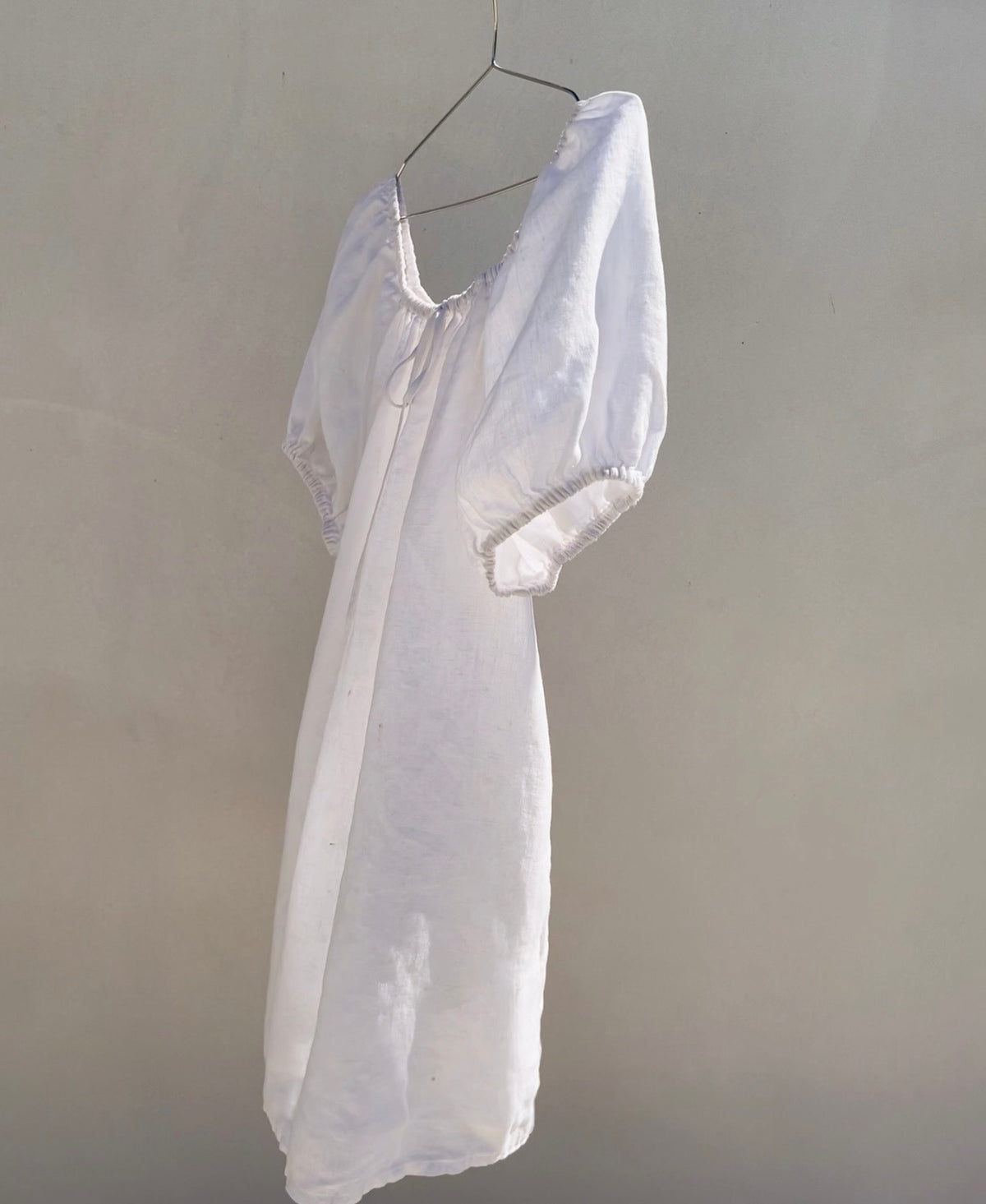 white linen grace ladies dress hanging in wind